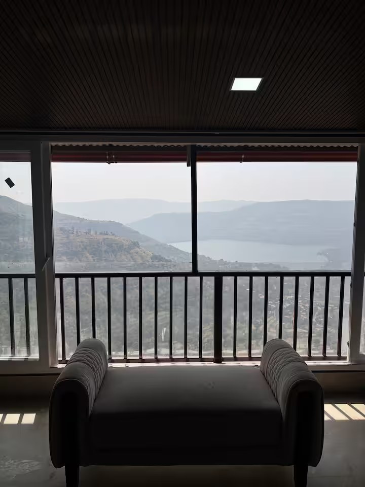 Indoor window seat with valley and dam view at Paramount's Vinayaka Homestay
